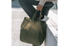 Image Man holding a reusable bag on the street.